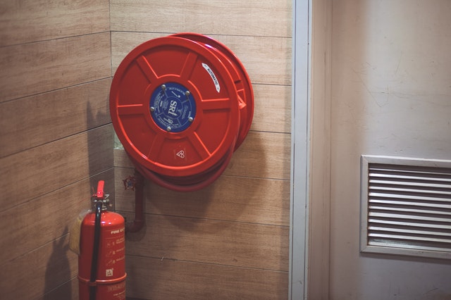 red-fire-extinguisher-beside-hose-reel-inside-the-room-189474