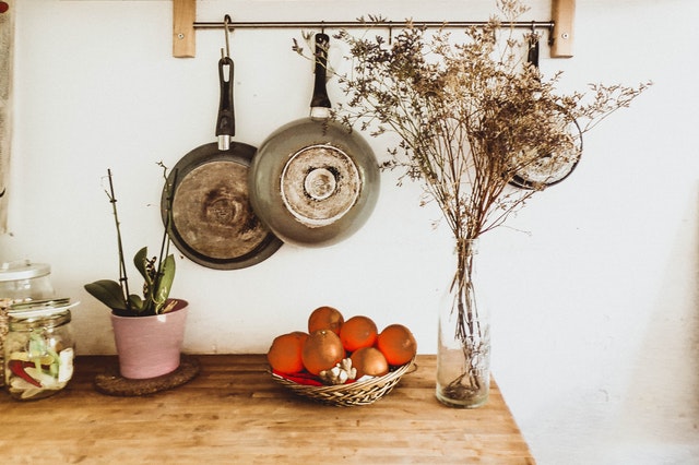 two-gray-frying-pans-hanging-on-wall-1128426